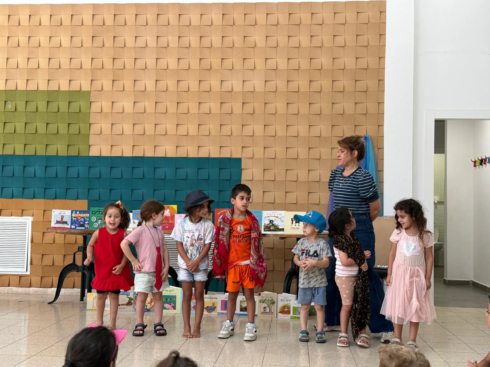 אליאור שניר עם ילדים מחופשים ליד ספרי ילדים
